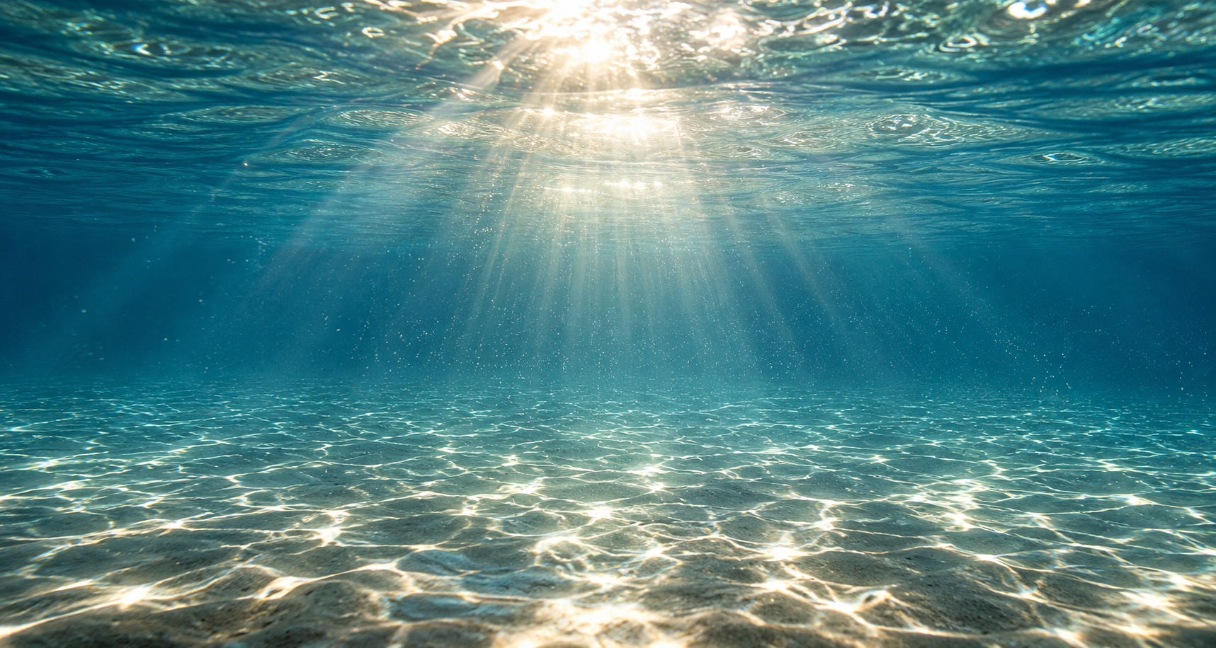 Sunlight streaming through clear blue water